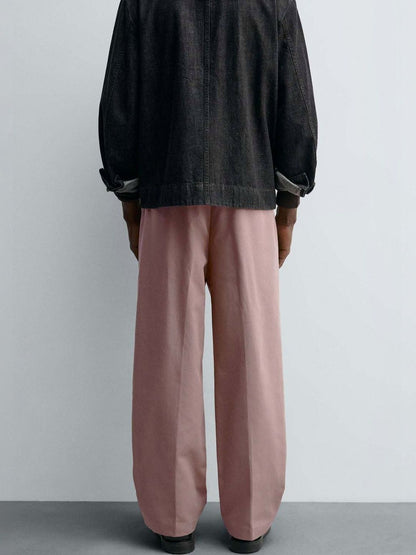Men Pleated Trousers in relaxed fit, solid pink color, styled with a dark jacket, perfect for casual Korean fashion.